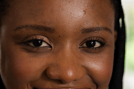 Smiling woman with natural makeup and braided hair, radiating confidence and warmth. Beauty,...