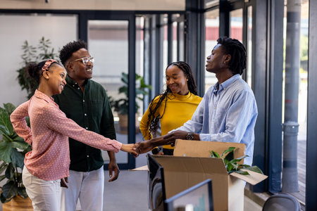 Colleagues greeting new team member with handshake in modern office setting. Coworkers, teamwork, collaboration, business, corporate, introductionの写真素材