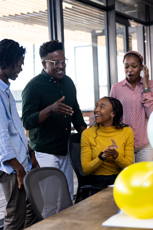 Team collaborating in modern office, smiling and discussing creative ideas together. Collaboration, teamwork, brainstorming, meeting, business, planningの写真素材