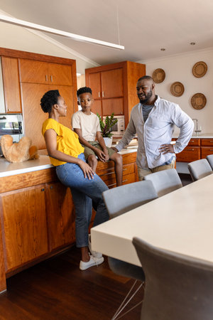 Family enjoying conversation in modern kitchen, sharing quality time together. togetherness, bonding, happinessの写真素材