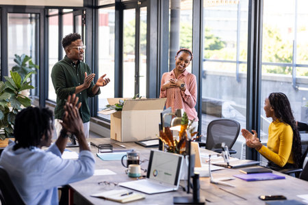 African American colleagues applauding in modern office during team celebration. Teamwork, achievement, business meeting, diversity, success, collaborationの写真素材