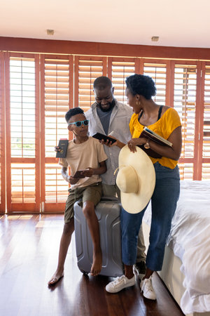 Family preparing for vacation, holding passports and luggage in bright bedroom. Travel, adventure, tourism, planning, packing, journeyの写真素材