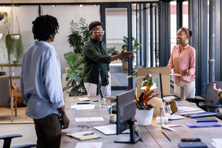 Colleagues discussing project ideas in modern office, smiling and collaborating. Teamwork,...