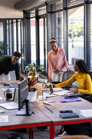 Collaborating in modern office, diverse team discussing project around table. Teamwork, brainstorming, collaboration, diversity, business, meetingの写真素材