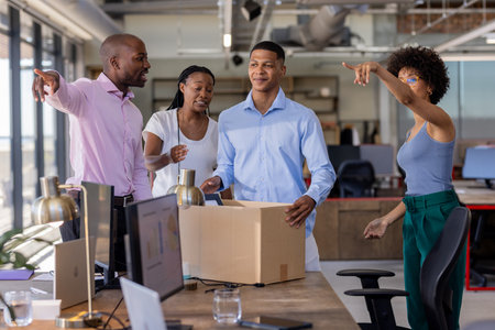 Colleagues unpacking box in modern office, discussing new project enthusiastically. Teamwork, collaboration, brainstorming, startup, coworkers, innovationの写真素材