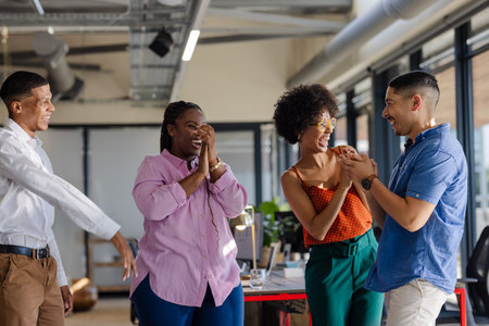 In office, diverse colleagues celebrating success, sharing joyful moments together. Teamwork, celebration, diversity, collaboration, business, coworkersの写真素材