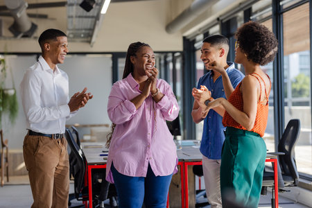 Colleagues in office clapping and smiling during successful team meeting. Teamwork, collaboration, celebration, corporate, business, professionalの写真素材