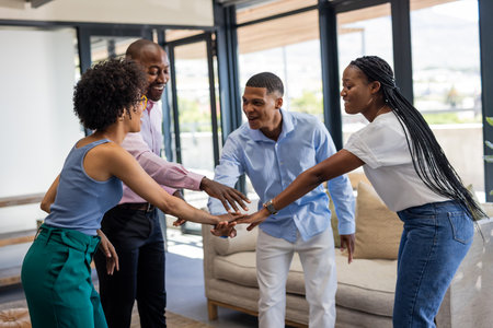 In office, diverse colleagues joining hands celebrating teamwork and collaboration success. unity,...