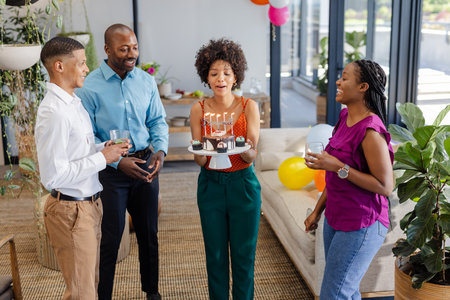 Colleagues celebrating birthday with cake and drinks in modern office lounge. Teamwork, celebration, corporate, collaboration, business, successの写真素材