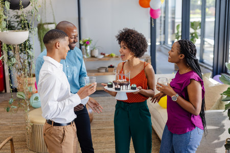 Colleagues celebrating birthday with cake and drinks in modern office setting. celebration, party, corporate, team building, workplace, gatheringの写真素材