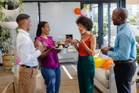 Colleagues celebrating birthday with cake and drinks in modern office lounge. Celebration, corporate culture, workplace, gathering, joyful, team bondingの写真素材