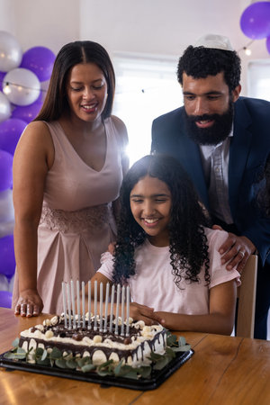 Family celebrating birthday with cake and candles, smiling and enjoying moment. Celebration, happiness, togetherness, party, joyful, traditionの写真素材