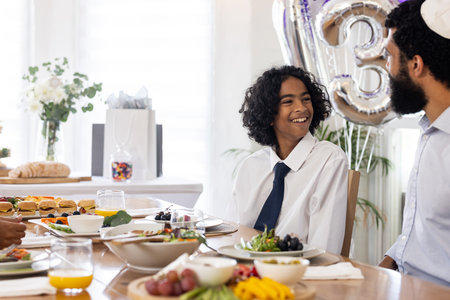 Smiling boy in white shirt enjoying festive meal with family at dining table. celebration, gathering, happiness, togetherness, culinary, eventの写真素材