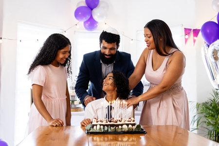 Family celebrating birthday with cake and candles, smiling and enjoying together. Celebration,...
