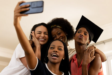 Friends celebrating graduation taking selfie together, smiling and enjoying moment. Celebration, friendship, achievement, diploma, group, partyの写真素材