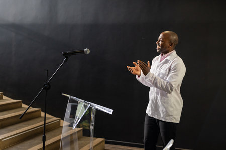 Presenting at podium with microphone, engaging audience confidently in meeting. public speaking, leadership, communication, presentation, corporate, conferenceの写真素材