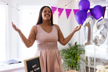 Celebrating special occasion, joyful woman with purple balloons and festive decorations. Celebration, female, party, cheerful, happinessの写真素材