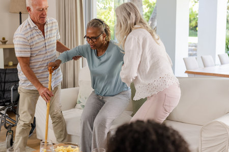 Senior friends supporting each other at home, helping with mobility and care. Friendship, caregiving, assistance, aging, companionship, senior careの写真素材