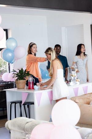 Friends celebrating at home with balloons and snacks, enjoying festive atmosphere. Celebration, party, friendship, decoration, happiness, gatheringの写真素材