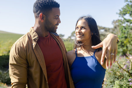 Smiling couple enjoying sunny day outdoors, celebrating engagement with happiness. romance, celebration, loveの写真素材
