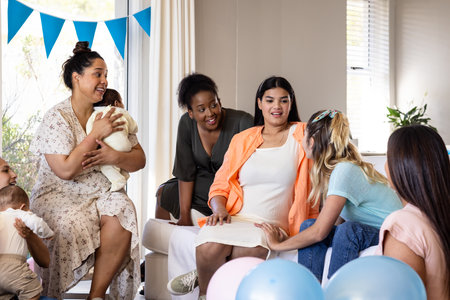 Women celebrating baby shower, smiling and chatting with balloons and decorations. Pregnancy, motherhood, celebration, party, friends, happinessの写真素材