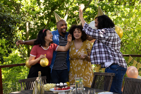 Celebrating outdoors, friends wearing party hats with balloons at festive gathering. Celebration, friendship, outdoor party, joyful, togetherness, funの写真素材