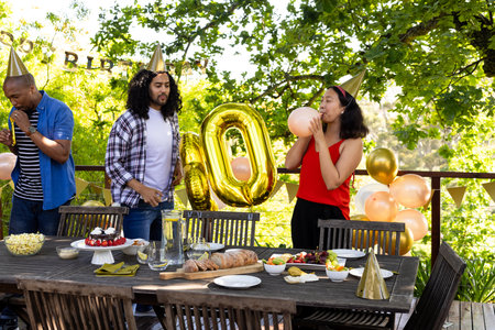 Friends preparing for outdoor birthday party with balloons and festive decorations. Celebration, gathering, outdoors, friendship, preparationの写真素材