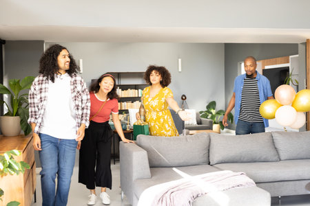 Friends gathering at home, smiling and enjoying celebration with balloons. togetherness, party, happiness, friendship, enjoymentの写真素材