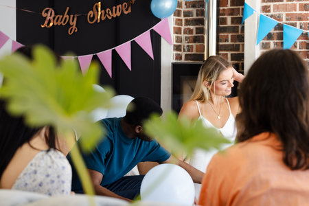 Celebrating baby shower, friends sharing joyful moments with decorations and balloons. celebration, party, happiness, gathering, female, togethernessの写真素材