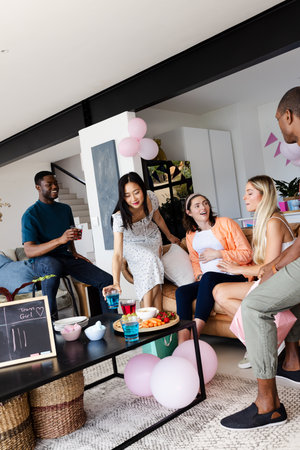 Friends enjoying casual gathering at home, chatting and sharing snacks together. socializing, togetherness, bonding, leisure, conversation, cozyの写真素材