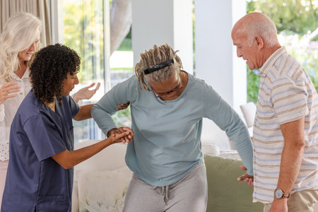 Assisting senior friends with mobility exercises at home, caregiver fostering independence. Elderly, support, homecare, rehabilitationの写真素材