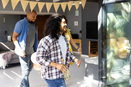 Friends arriving at party, carrying drinks and smiling, ready to celebrate indoors. Celebration, gathering, friendship, beverages, happiness, socializing