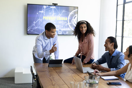 Diverse team discussing project strategy with laptops in modern office meeting. Collaboration, teamwork, brainstorming, business, technology, innovation