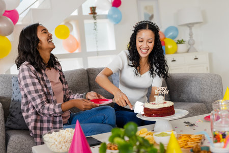 Celebrating birthday, two women laughing and cutting cake at home party. Celebration, friendship,...