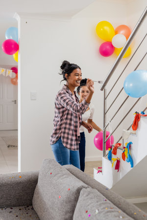 Mother and daughter decorating staircase with colorful balloons for birthday party. Family, celebration, festive, decorations, bonding, joyfulの写真素材