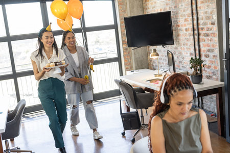 Celebrating in office, colleagues with cupcakes and balloons, creating joyful atmosphere. Teamwork, collaboration, party, office culture, happiness, corporateの写真素材