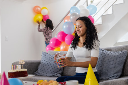 Teen girl decorating home with colorful balloons for birthday party, smiling. Celebration, joy, festive, decorations, happiness, eventの写真素材