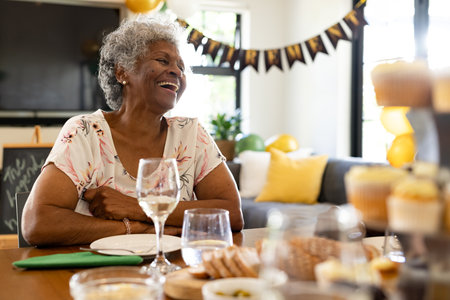 Elderly woman laughing joyfully at home during festive celebration with family. happiness, togethernessの写真素材