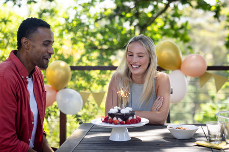 Celebrating birthday outdoors, friends with cake and balloons sharing joyful moments. Celebration, party, happiness, gathering, fun, eventの写真素材