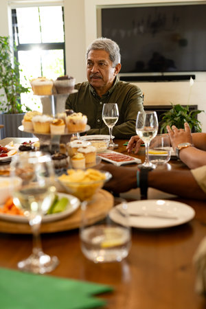 Family enjoying festive meal together at home, sharing laughter and conversation. celebration,...