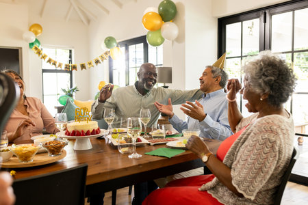 Celebrating birthday with cake, family laughing and enjoying decorations together. Celebration, party, happiness, family gathering, candles, surpriseの写真素材