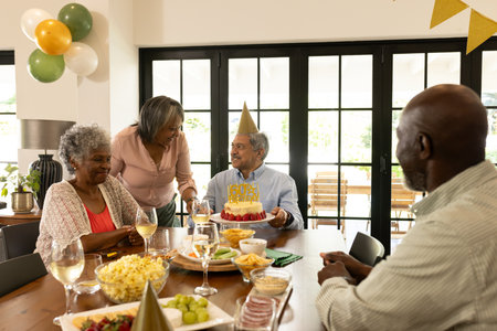 Family celebrating birthday at home with cake, balloons, and joyful conversation. Celebration, birthday party, togetherness, cheerful, happiness, festiveの写真素材