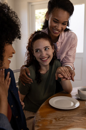 Friends celebrating engagement at home, smiling and sharing joyful moments together. Celebration, friendship, happiness, party, gathering, excitedの写真素材