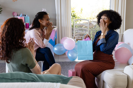 Women celebrating baby shower at home, exchanging gifts and sharing joyful moments. Pregnancy, motherhood, celebration, gift exchange, happiness, friendshipの写真素材
