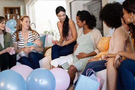 Women celebrating baby shower at home, sharing gifts and joyful conversations. Celebration, family, friendship, motherhood, happiness, social eventの写真素材