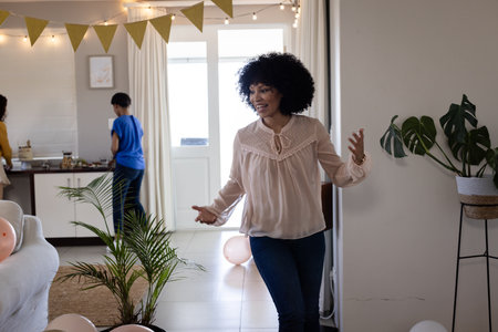 Smiling woman celebrating at home with balloons and festive decorations. Celebration, party, happiness, joyfulの写真素材