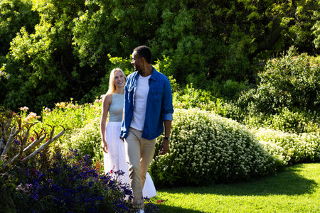 Couple walking in lush garden, enjoying nature and each other's company. romance, relationship, greenery, flora, outdoorsの写真素材