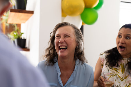Laughing joyfully, senior woman at lively celebration with friends outdoors. happiness, friendship,...