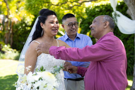 Greeting guests, bride in white dress smiling at outdoor senior wedding ceremony. celebration, outdoors, happiness, love, romanceの写真素材