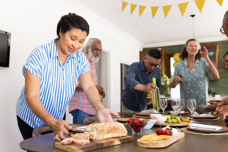 Preparing table with bread and wine, senior friends party at home. Hospitality, friendship, celebration, meal, cozy, togethernessの写真素材